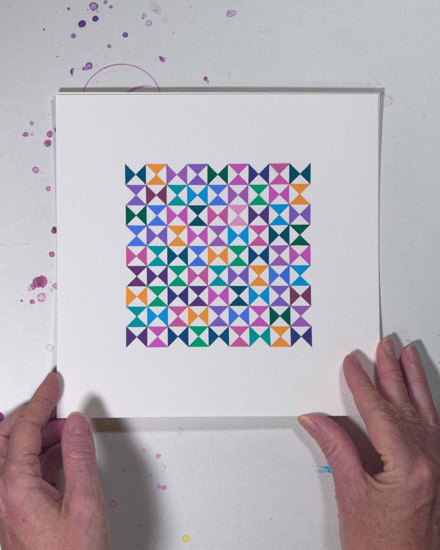 Hands holding a bold, graphic multicoloured abstract painting with repeating geometric shapes, 30 July – 030/365 by Victoria Mardon, 365: A Year in Colour series.