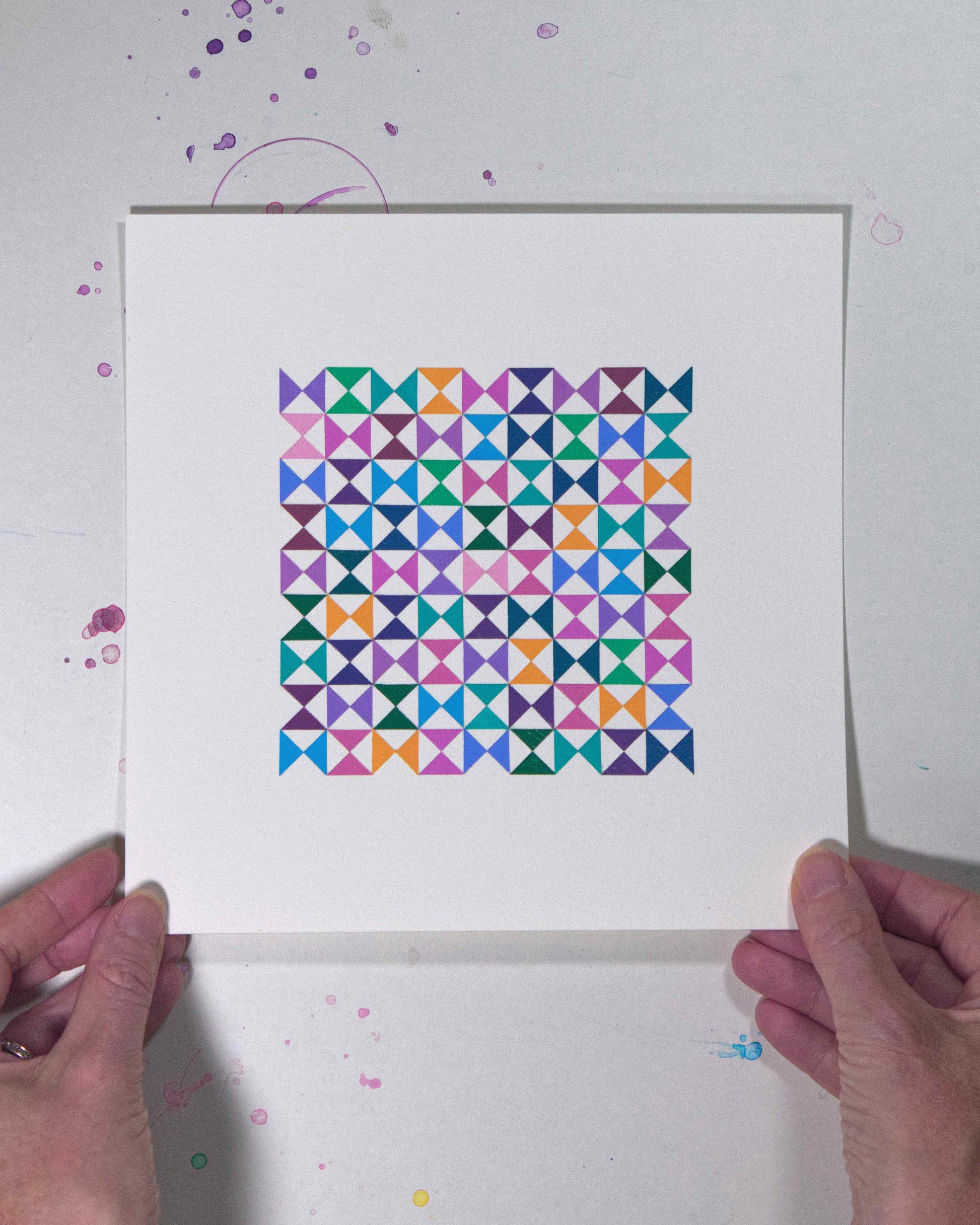 Hands holding a bold, graphic multicoloured abstract painting with repeating geometric shapes, 31 July – 031/365 by Victoria Mardon, 365: A Year in Colour series.