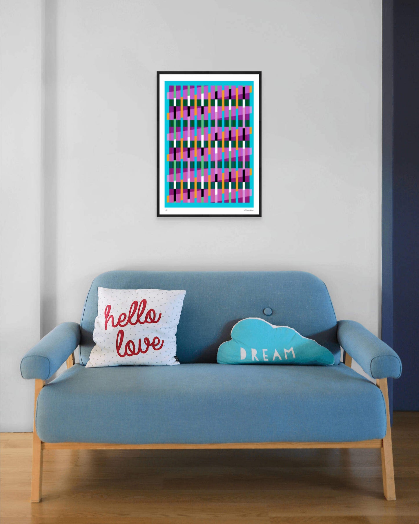 Blue geometric abstract giclée print by Victoria Mardon in a black frame displayed above a blue mid-century sofa