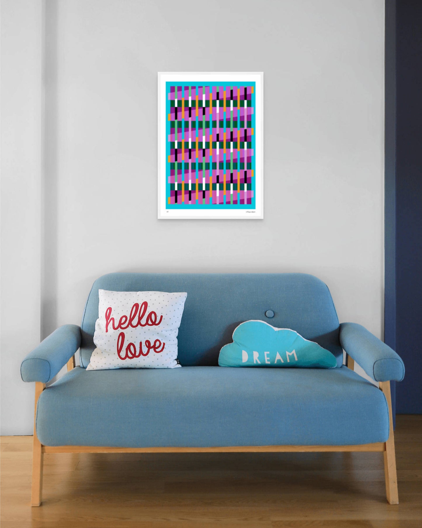 Blue geometric abstract giclée print by Victoria Mardon in a white frame displayed above a blue mid-century sofa