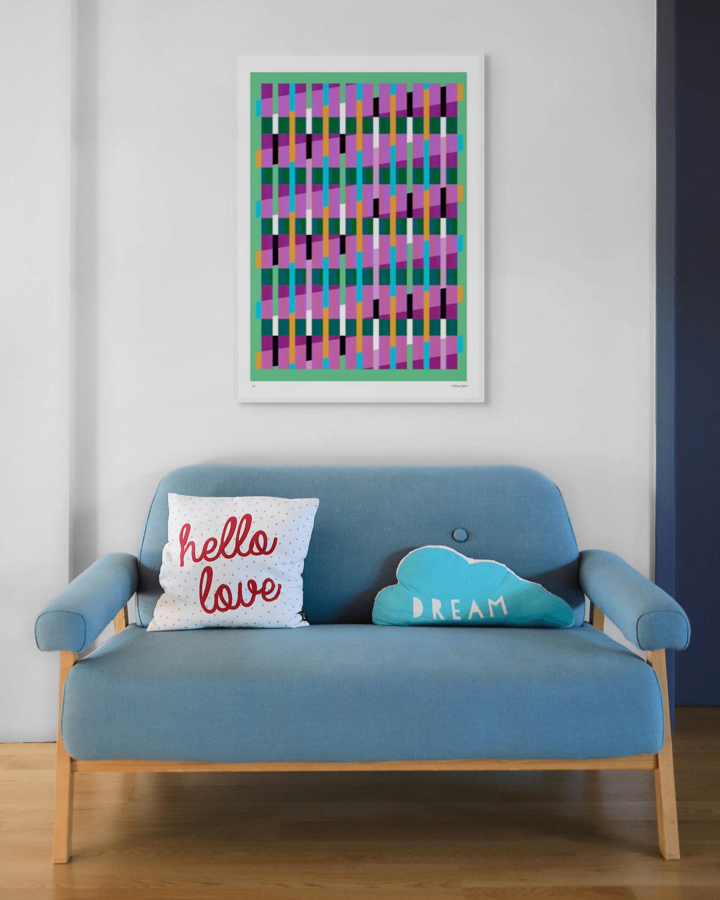 Green geometric abstract giclée print by Victoria Mardon in a white frame displayed above a blue mid-century sofa