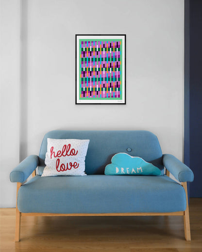 Green geometric abstract giclée print by Victoria Mardon in a black frame displayed above a blue mid-century sofa