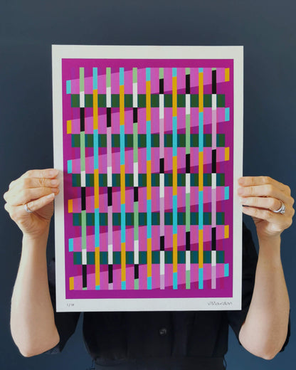 Magenta geometric abstract giclée print by Victoria Mardon held in hands against a dark background