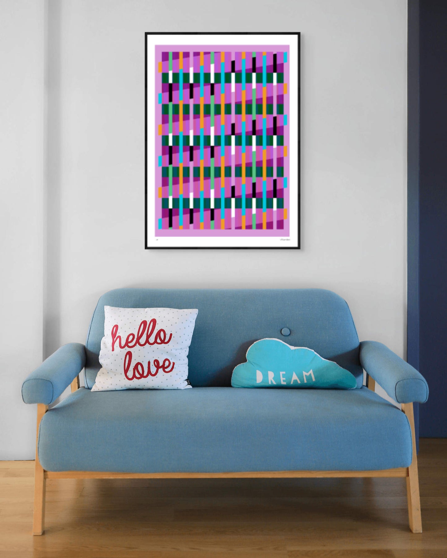 Pink geometric abstract giclée print by Victoria Mardon in a black frame displayed above a blue mid-century sofa