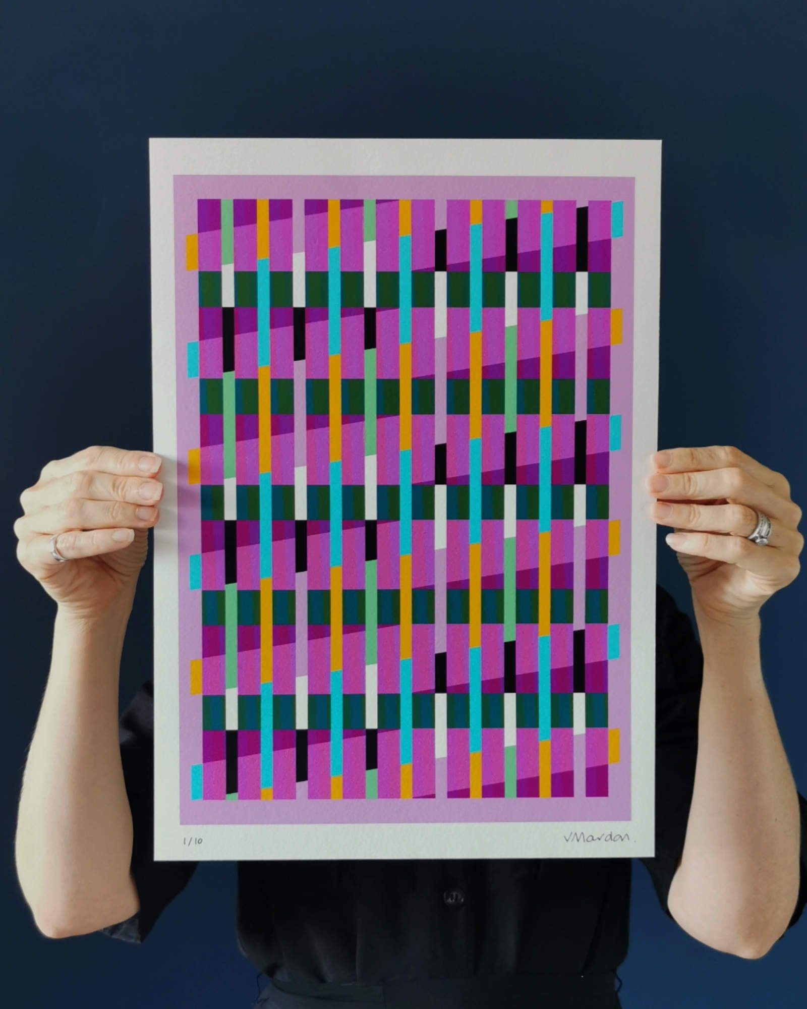 Pink geometric abstract giclée print by Victoria Mardon held in hands against a dark background