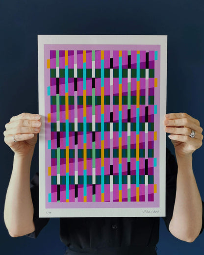 Pink geometric abstract giclée print by Victoria Mardon held in hands against a dark background