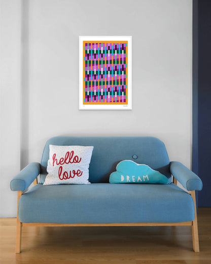 Yellow geometric abstract giclée print by Victoria Mardon in a white frame displayed above a blue mid-century sofa