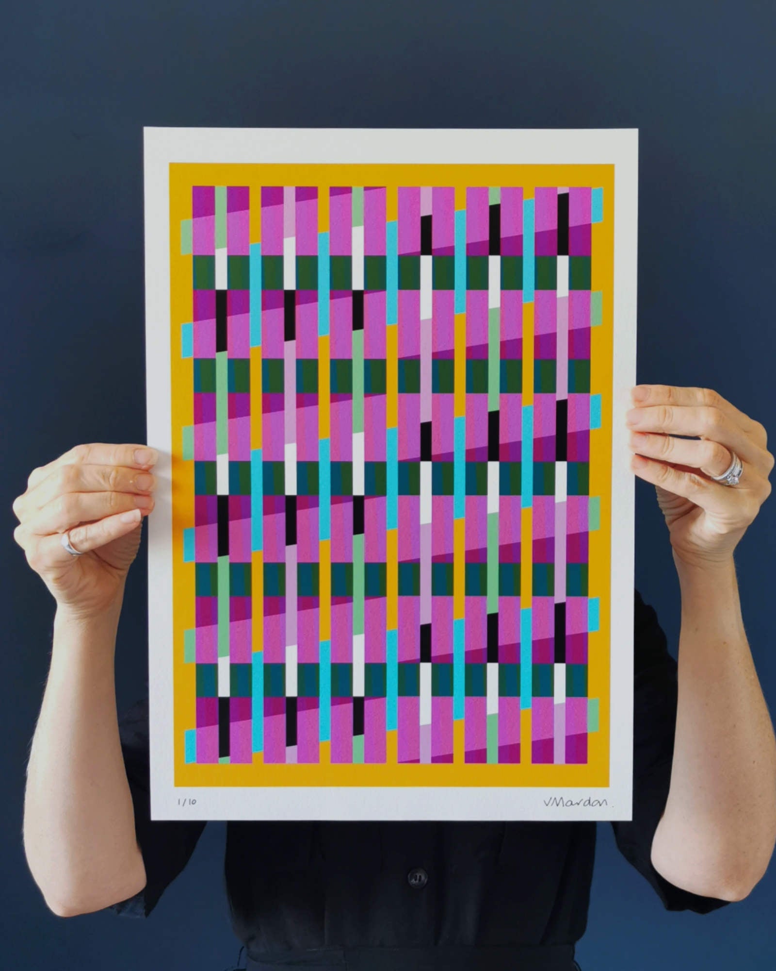 Yellow geometric abstract giclée print by Victoria Mardon held in hands against a dark background